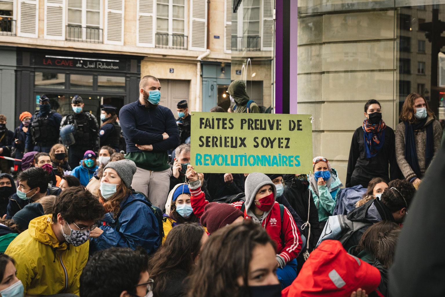 Rebelle portant une pancarte « Faites preuve de sérieux, soyez révolutionnaire »